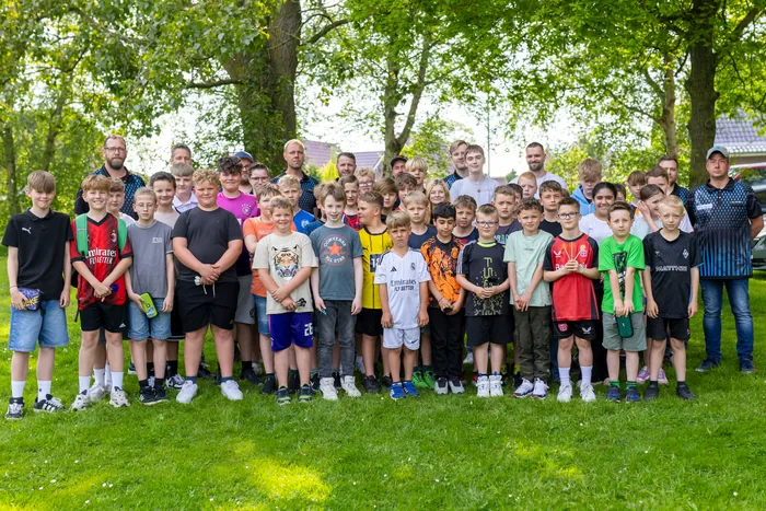 Gruppenbild vom Kinderdartturnier: rund vierzig Kinder mit ihren Betreuern auf der Wiese vor dem Vereinsheim