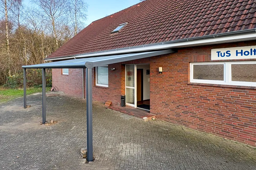 Das Vereinsheim des TuS Holthusen, ein Backsteingebäude mit überdachtem Eingang