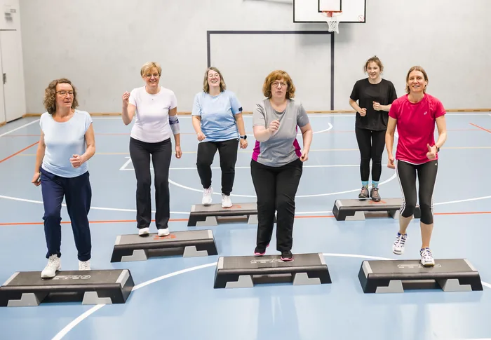 Sechs Frauen der Dienstagsgruppe beim Training auf Steppbrettern in der Turnhalle