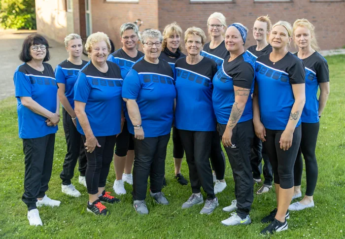 Die Völkerball-Damen des TuS Holthusen in blau-schwarzen Trikots vor dem Vereinsheim